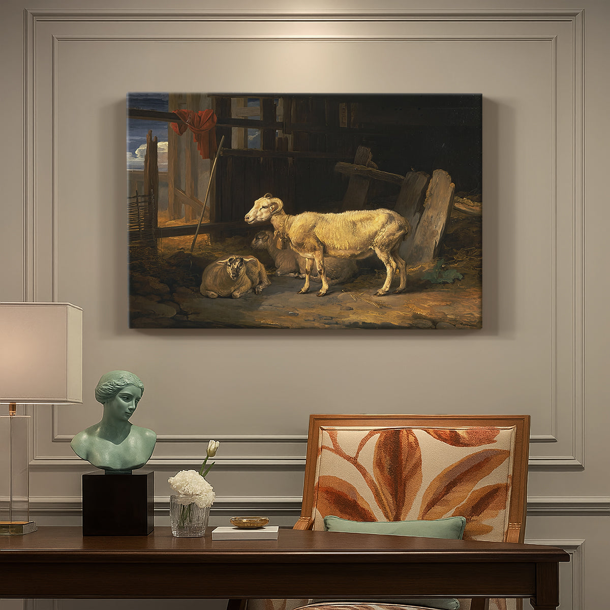 Canvas art print featuring a group of sheep gathered inside dimly lit stable interior, presented within a refined interior setting