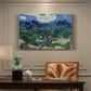 Canvas art print featuring an olive grove with twisted trees set before distant mountain range, presented within a refined interior setting