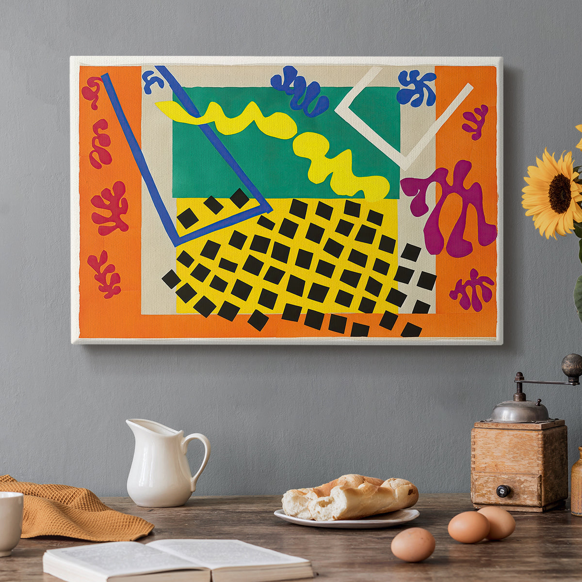 Canvas art print featuring an abstract arrangement of organic cut-out shapes in bold contrasting colors, set in a cozy kitchen setting