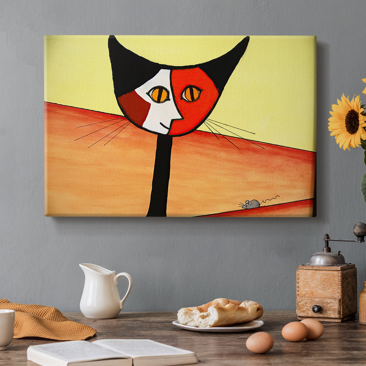 Canvas art print featuring a stylized cat face composed of bold geometric shapes, set in a cozy kitchen setting