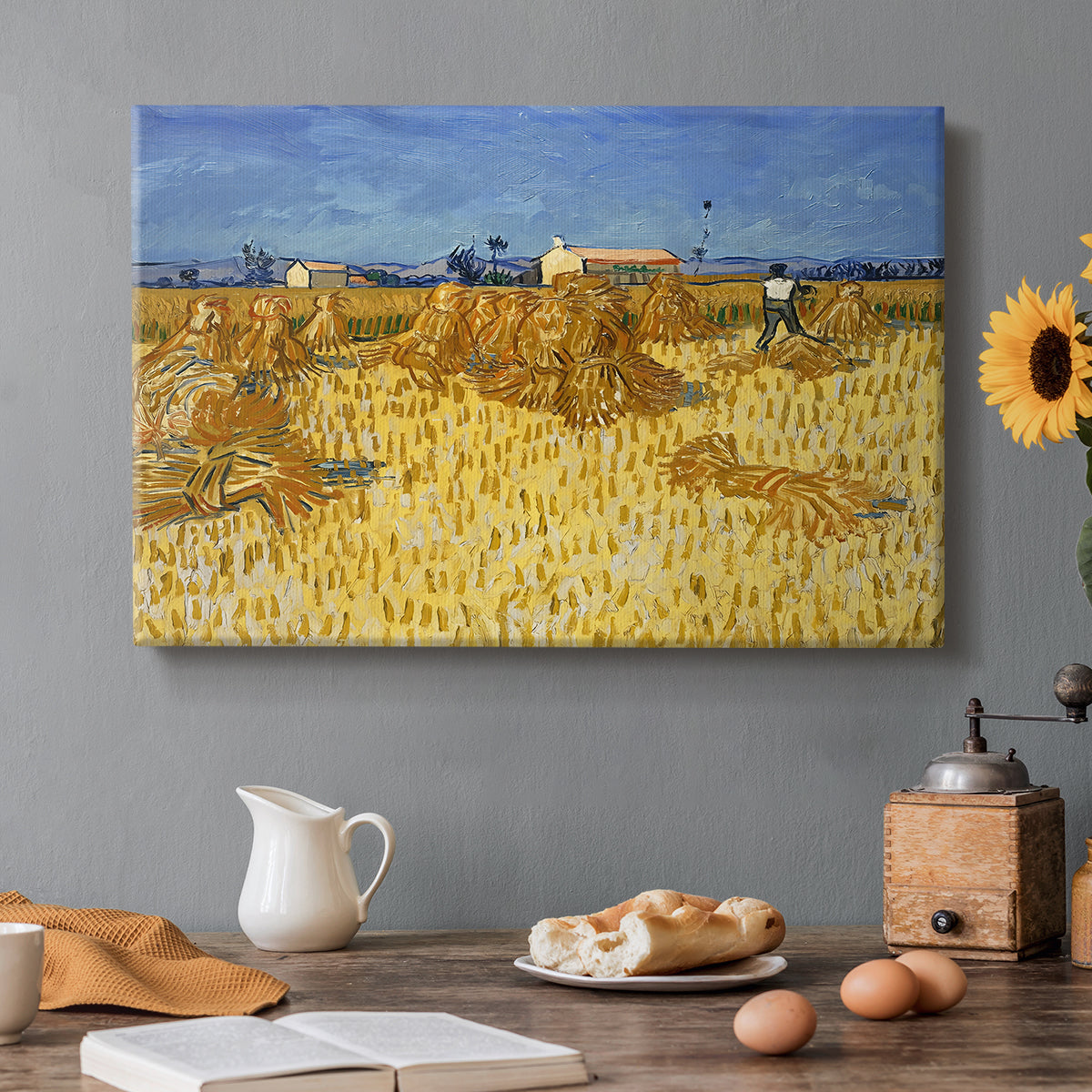 Canvas art print featuring stacked bundles of wheat arranged across harvested field under open sky, set in a cozy kitchen setting