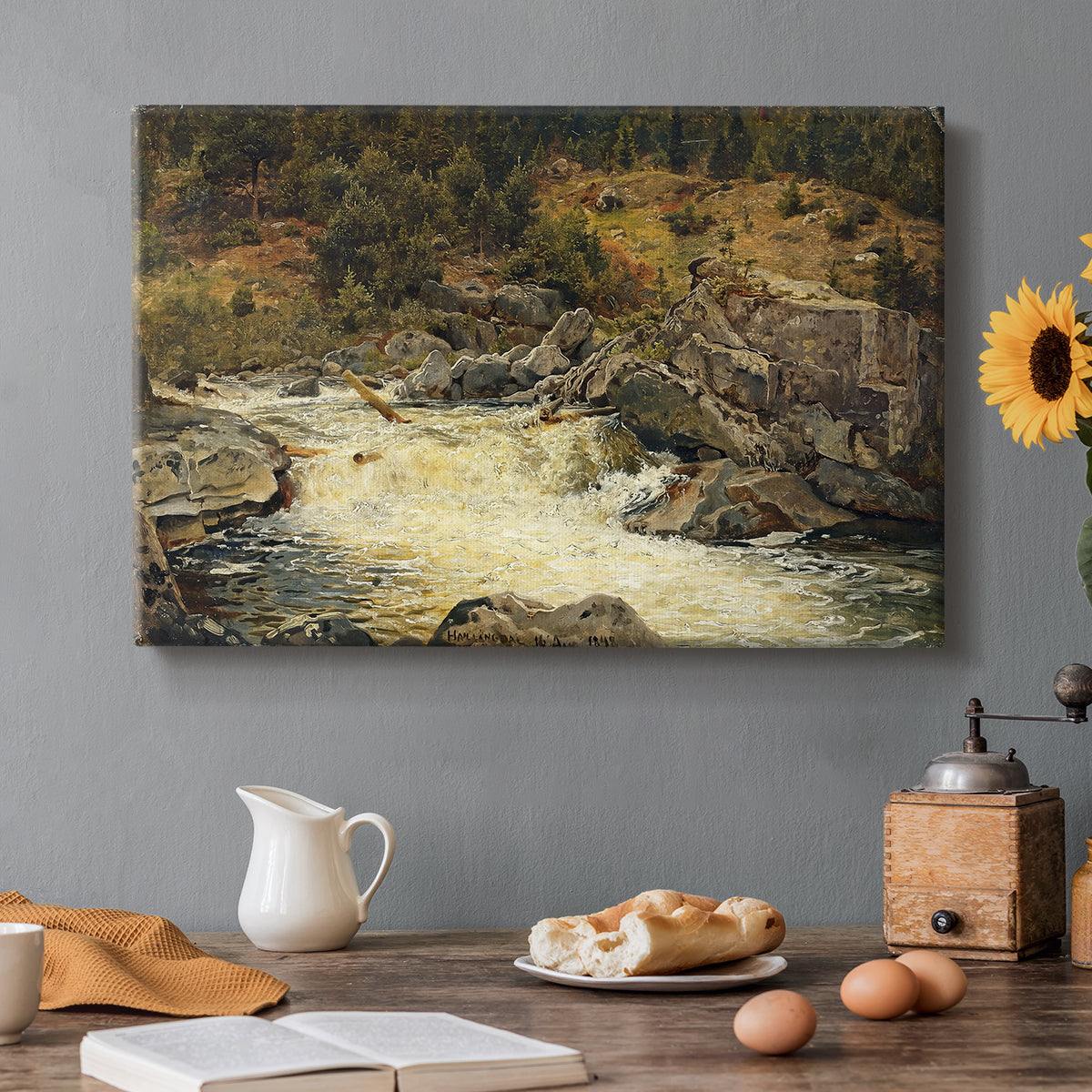 Canvas art print featuring a waterfall cascading down rocky slope surrounded by forest, set in a cozy kitchen setting