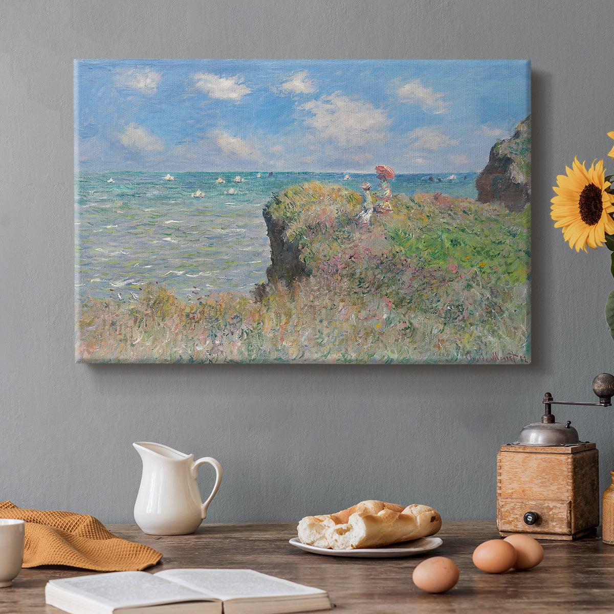 Canvas art print featuring figures walking along coastal cliff path overlooking ocean and sky, set in a cozy kitchen setting
