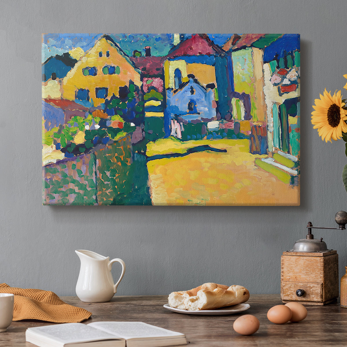 Canvas art print featuring a village street with colorful houses and trees lining a narrow road, set in a cozy kitchen setting
