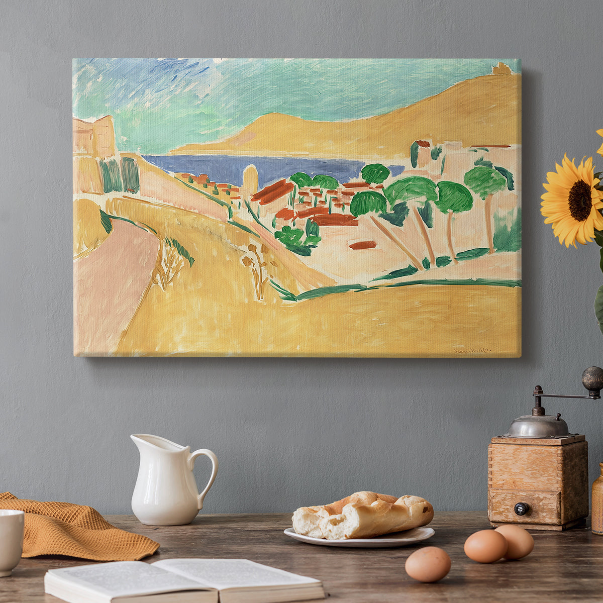 Canvas art print featuring a bright coastal townscape with buildings, water, and vivid colors, set in a cozy kitchen setting
