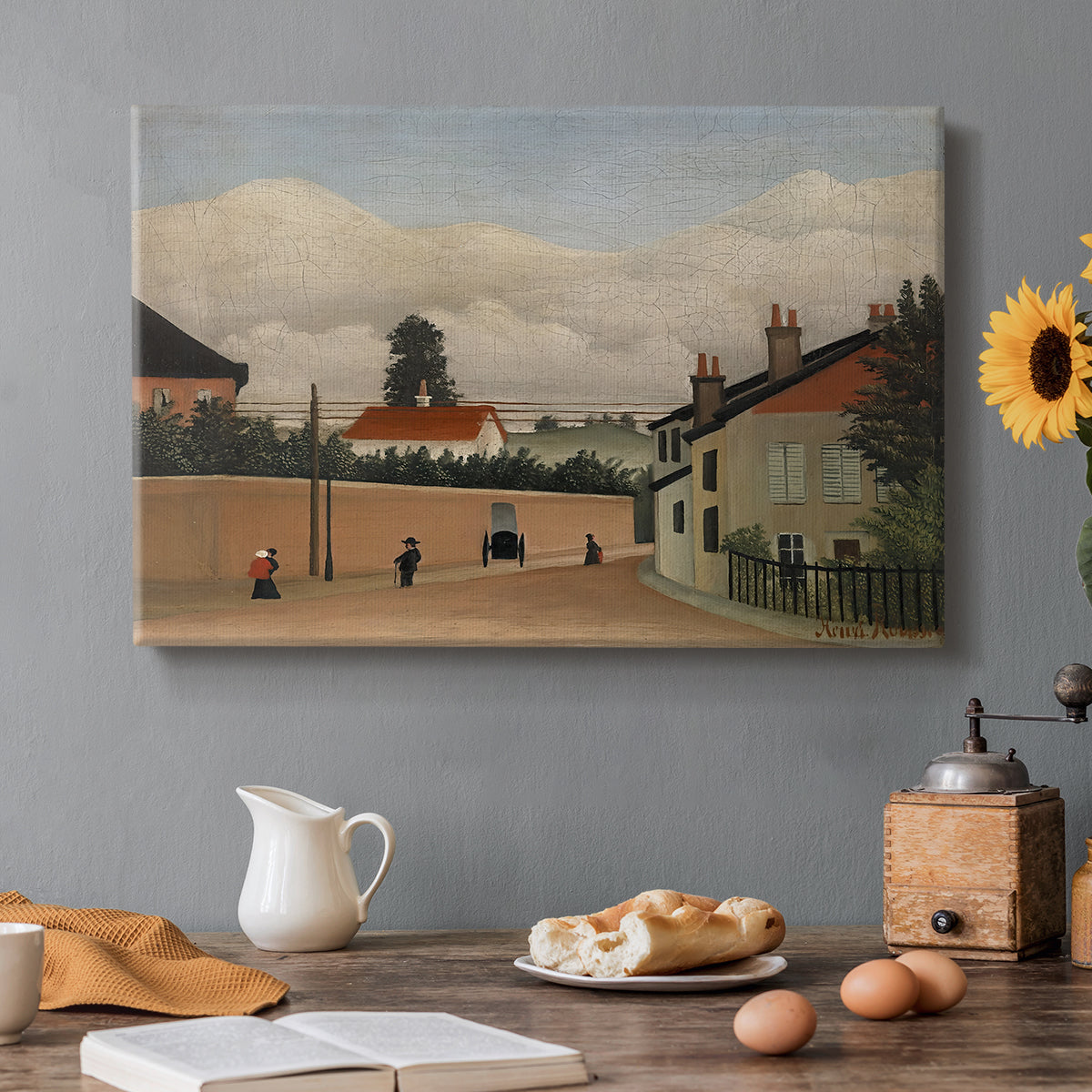 Canvas art print featuring a quiet suburban landscape with buildings, road, and open terrain, set in a cozy kitchen setting