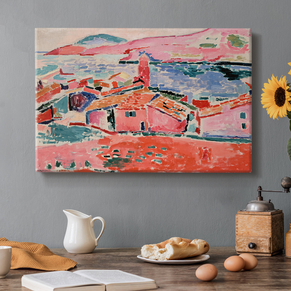 Canvas art print featuring a colorful coastal townscape with buildings, water, and bright rooftops, set in a cozy kitchen setting