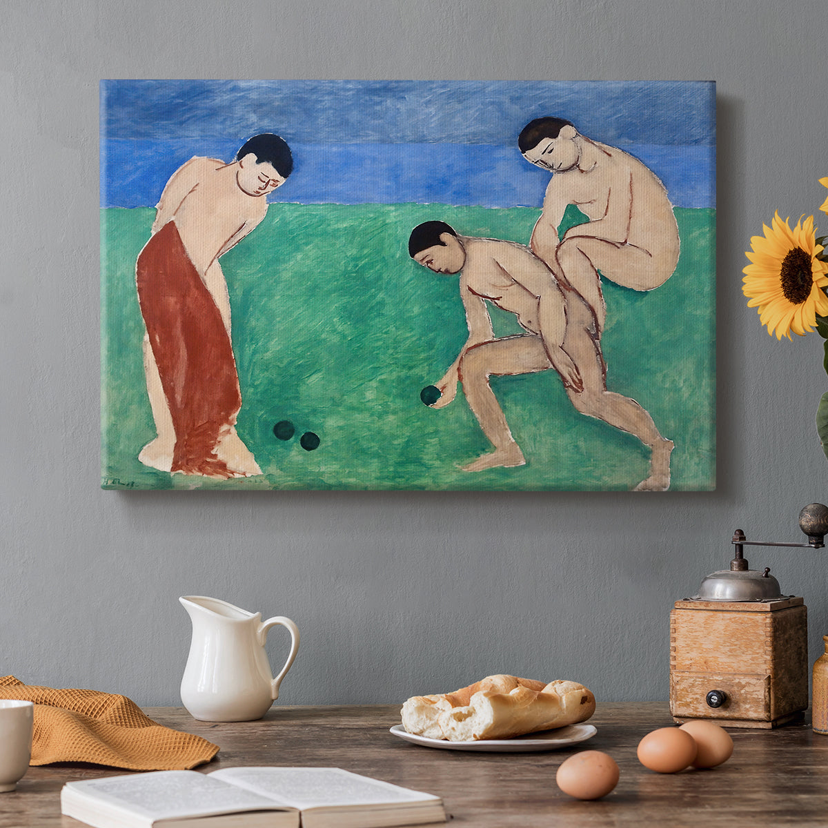 Canvas art print featuring figures playing bowls outdoors in a simplified colorful landscape, set in a cozy kitchen setting