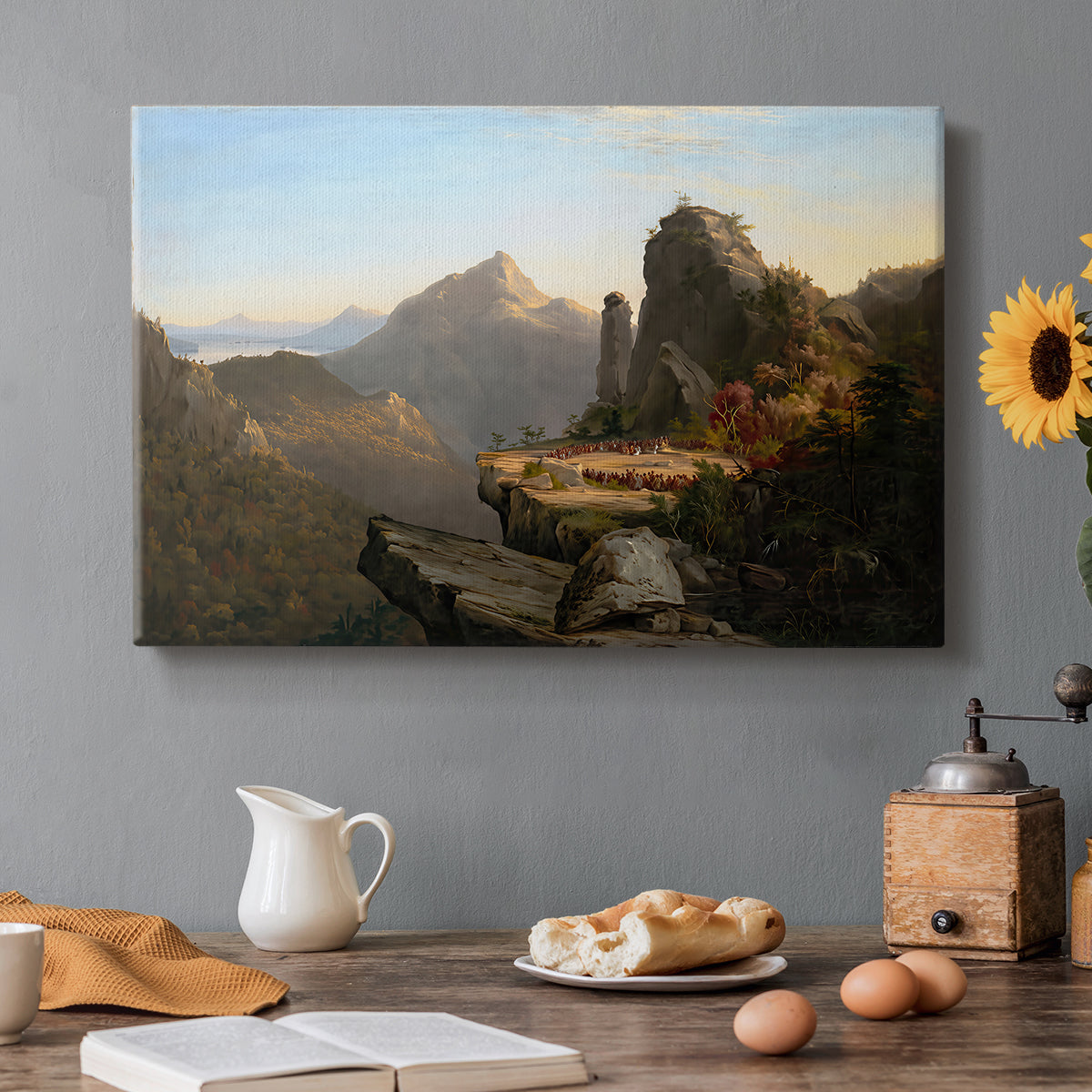 Canvas art print featuring a rugged mountain landscape with small figures near water and rocky cliffs, set in a cozy kitchen setting