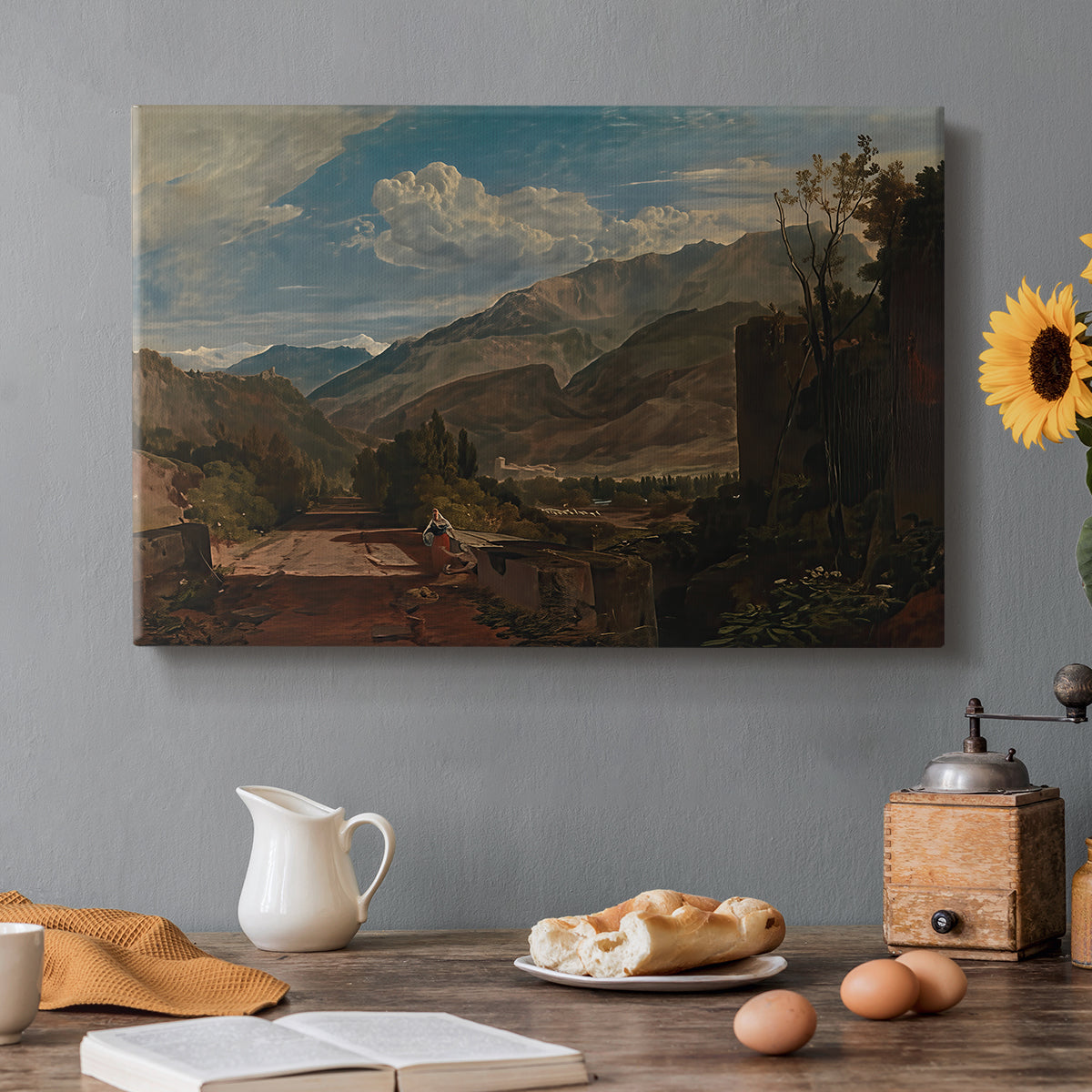 Canvas art print featuring a mountain landscape with town and river under dramatic sky, set in a cozy kitchen setting