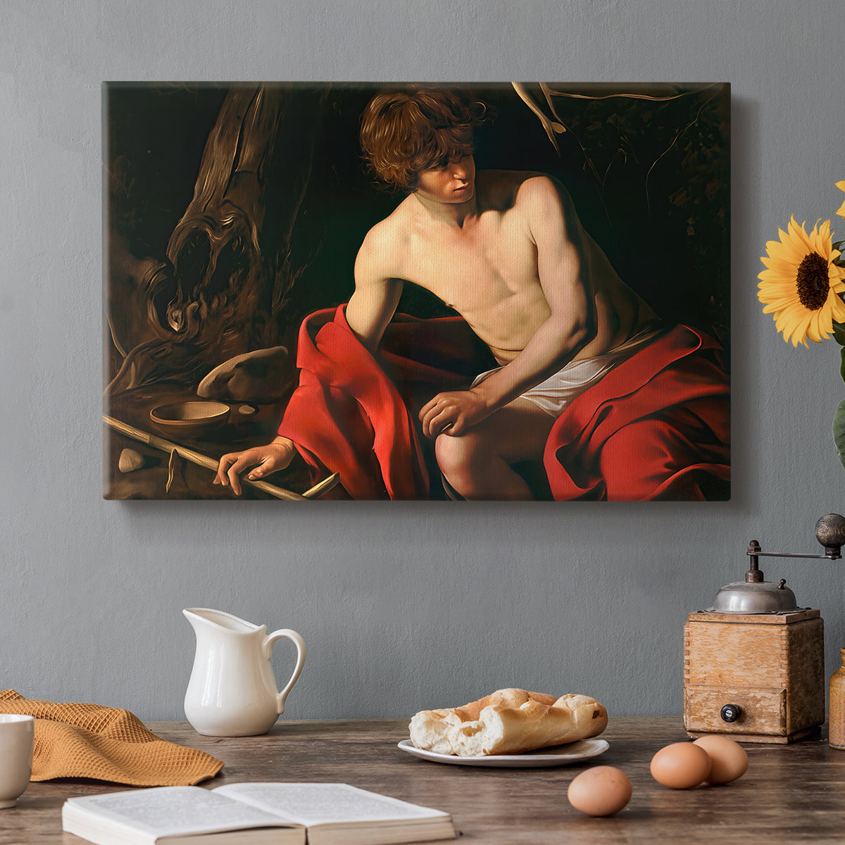 Canvas art print featuring a young Saint John seated in wilderness with staff and red drapery, set in a cozy kitchen setting
