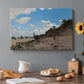 Canvas art print featuring a coastal beach scene with figures gathered along shoreline and boats nearby, set in a cozy kitchen setting