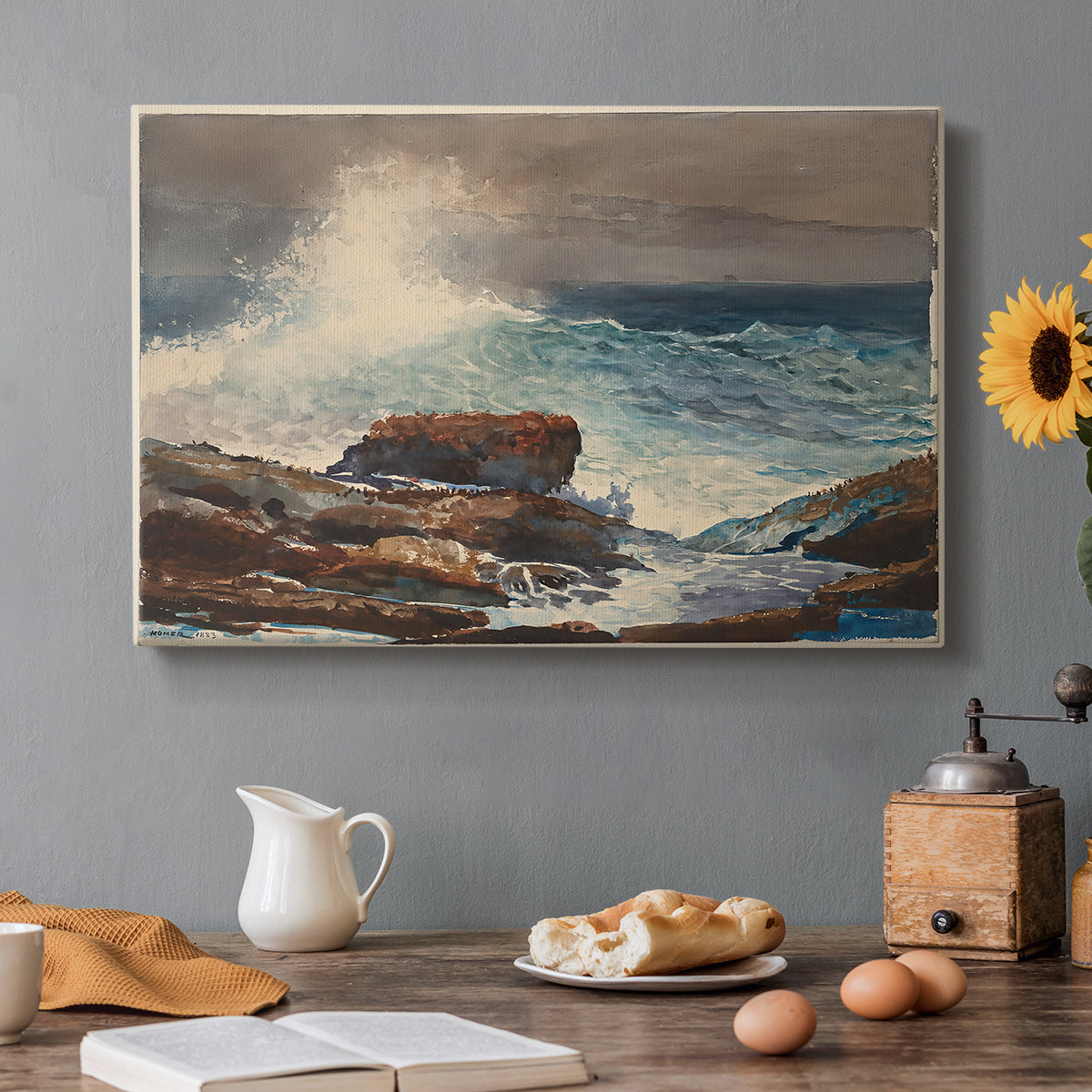 Canvas art print featuring waves rolling toward rocky shoreline with low buildings nearby, set in a cozy kitchen setting