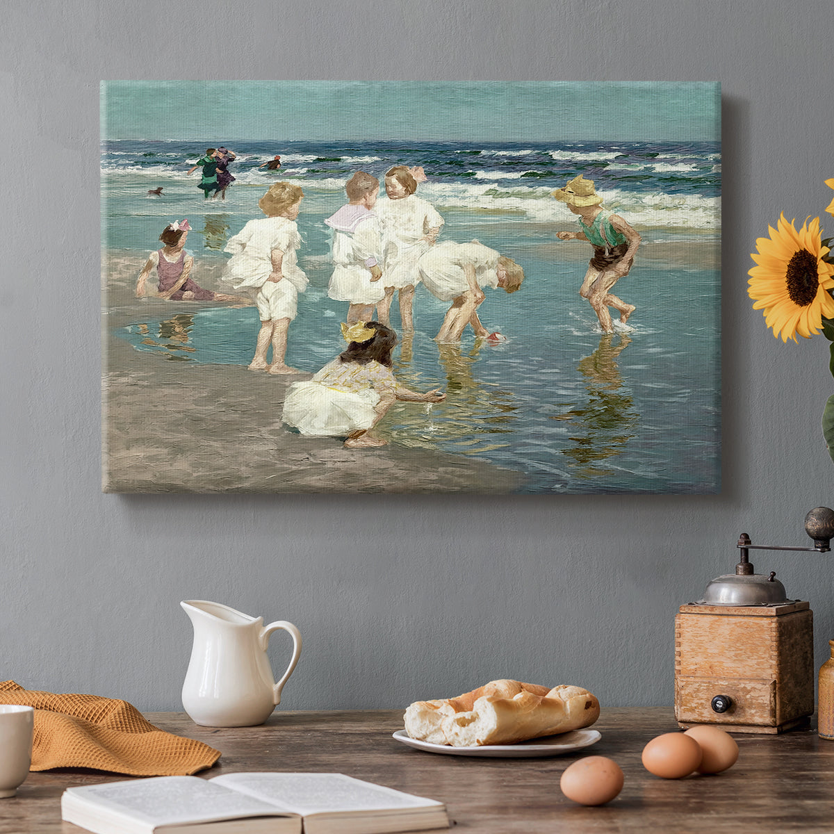 Canvas art print featuring people relaxing and wading in shallow ocean water along a sunny beach, set in a cozy kitchen setting