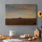 Canvas art print featuring a low mountain landscape under warm sky with broad open foreground, set in a cozy kitchen setting