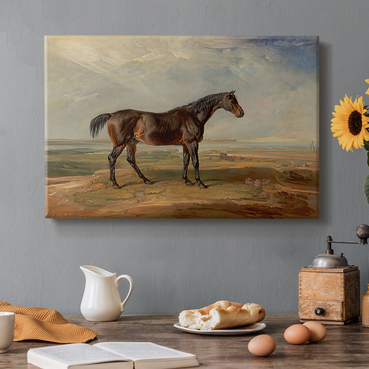 Canvas art print featuring a racehorse standing near coastal landscape with distant water, set in a cozy kitchen setting