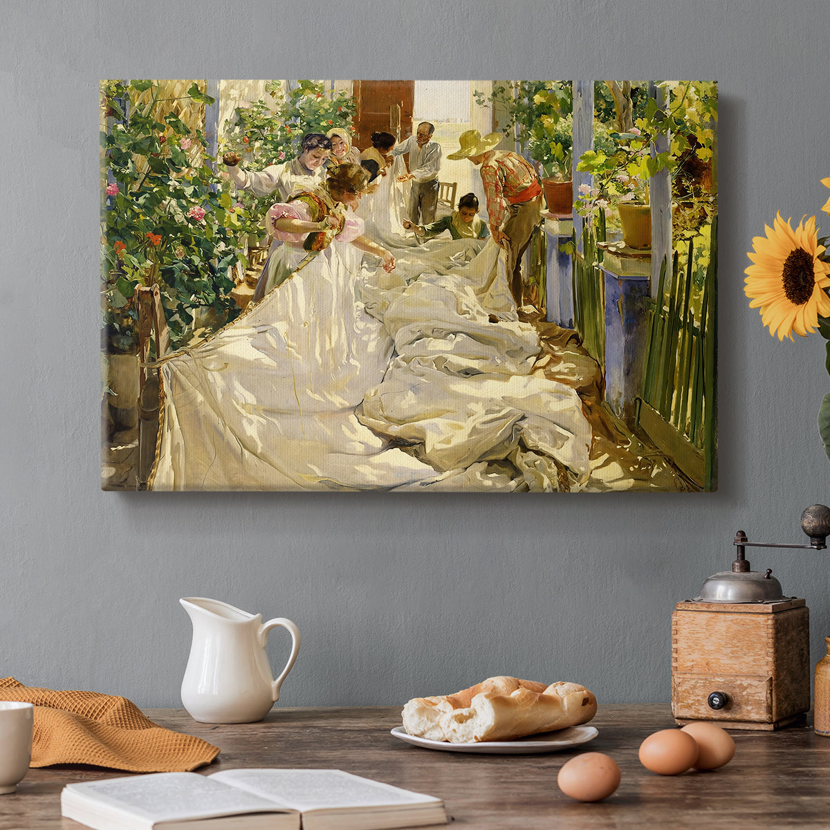 Canvas art print featuring figures working together sewing large sail outdoors in bright light, set in a cozy kitchen setting