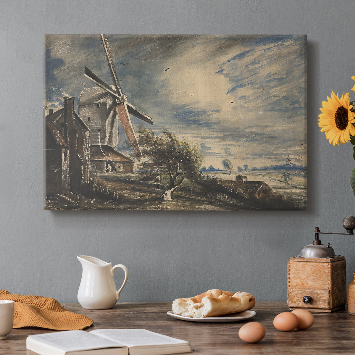 Canvas art print featuring a rural mill beside water surrounded by trees, set in a cozy kitchen setting