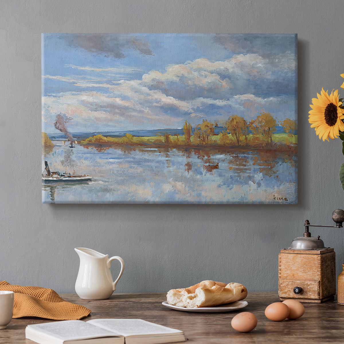Canvas art print featuring a riverside landscape with water trees and distant structures, set in a cozy kitchen setting