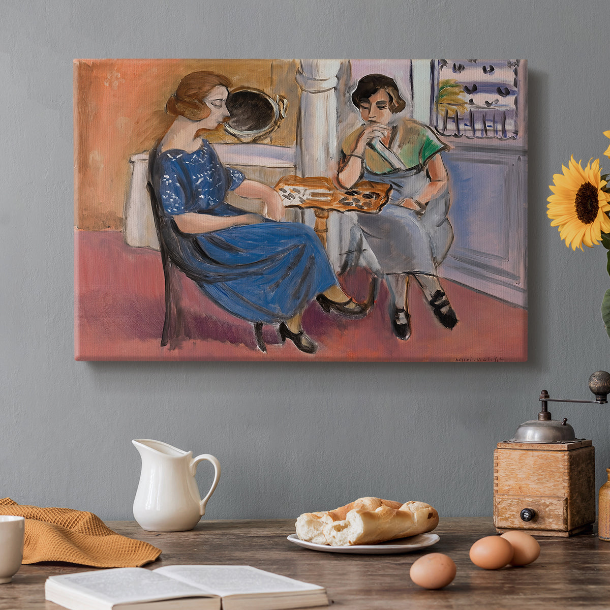 Canvas art print featuring two figures seated at a table playing dominoes in a colorful interior, set in a cozy kitchen setting