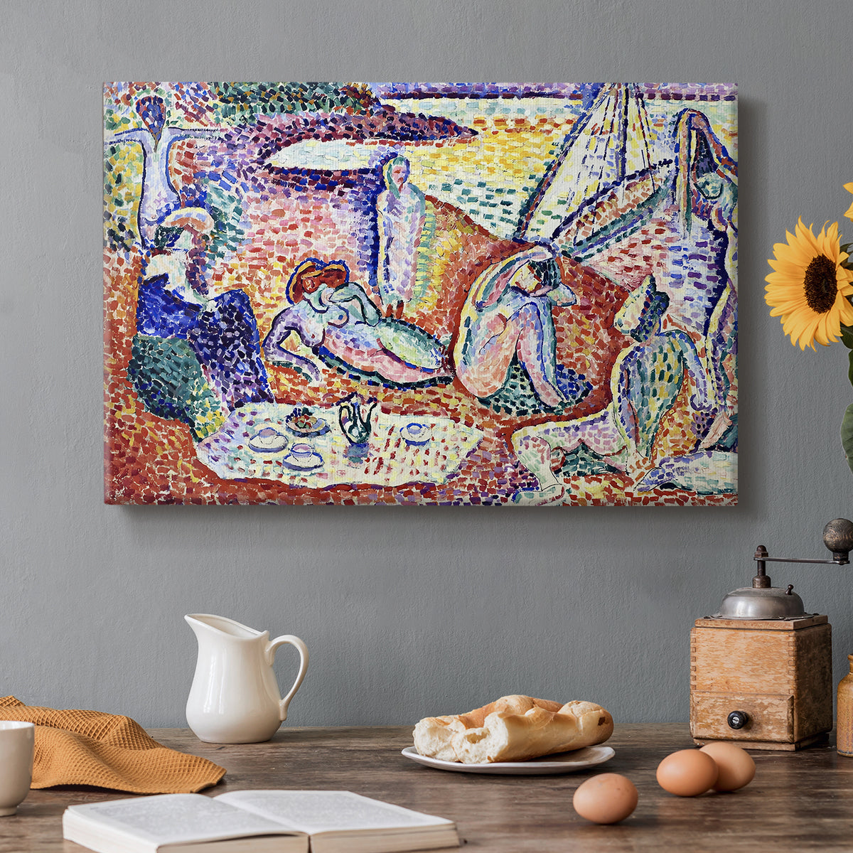 Canvas art print featuring figures lounging outdoors in a vibrant coastal setting with water views, set in a cozy kitchen setting