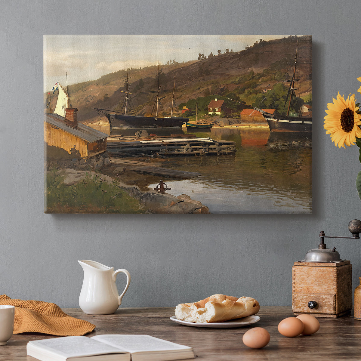 Canvas art print featuring a small harbor with boats docked along shoreline near buildings, set in a cozy kitchen setting