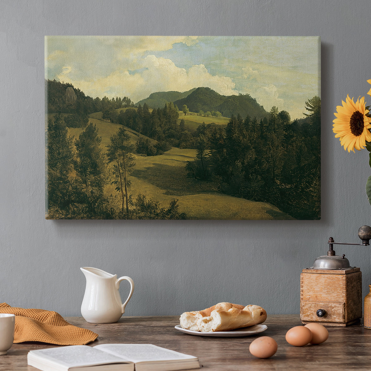Canvas art print featuring a rolling countryside with trees and distant hills, set in a cozy kitchen setting