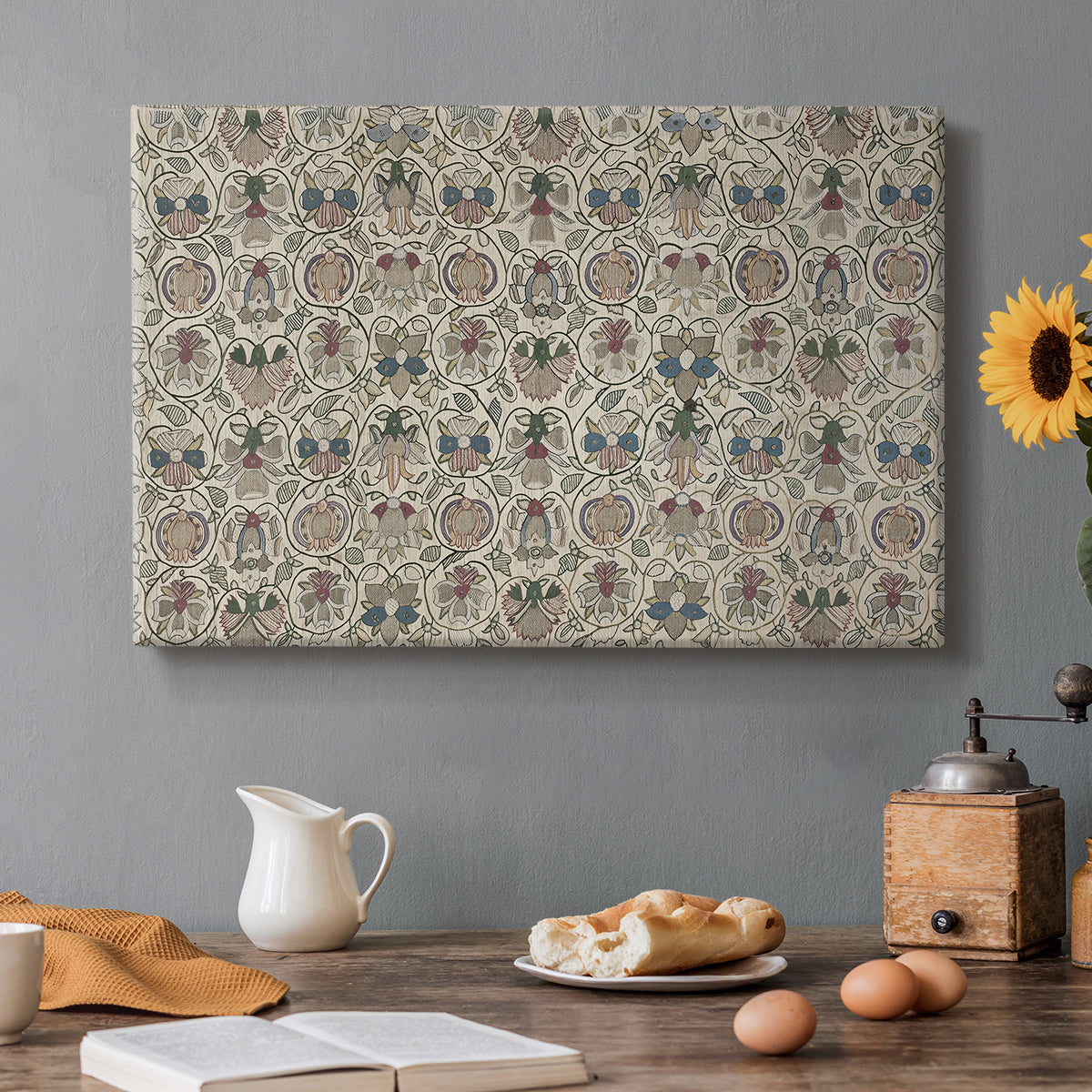 Canvas art print featuring a repeating floral pattern with symmetrical layout across elongated textile surface, set in a cozy kitchen setting