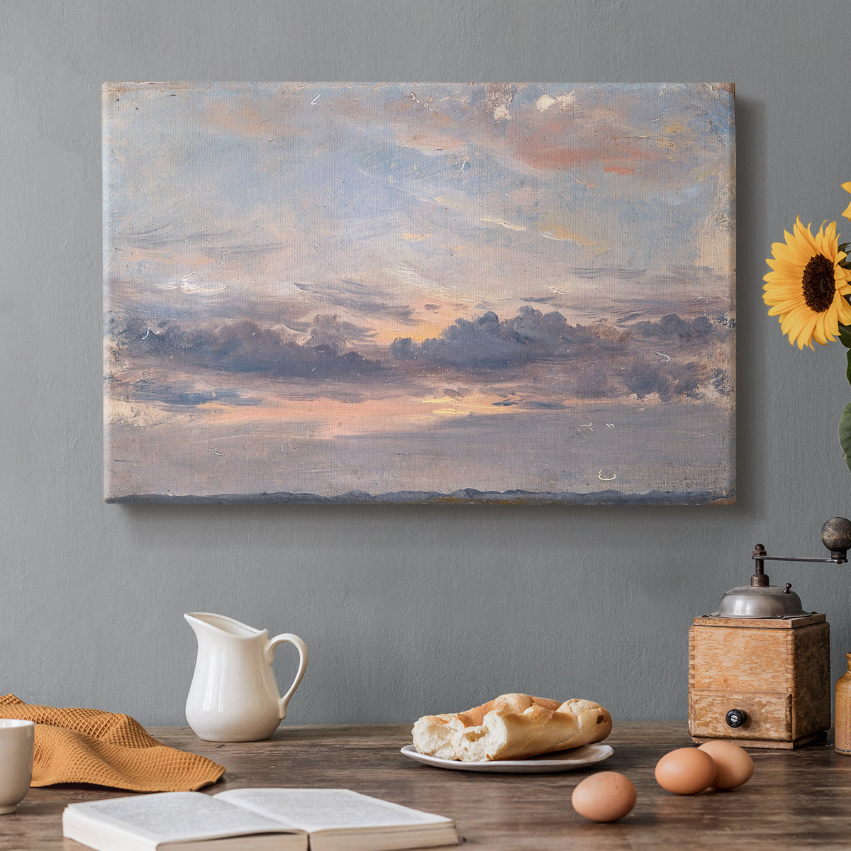 Canvas art print featuring a sky filled with warm sunset clouds over low horizon, set in a cozy kitchen setting