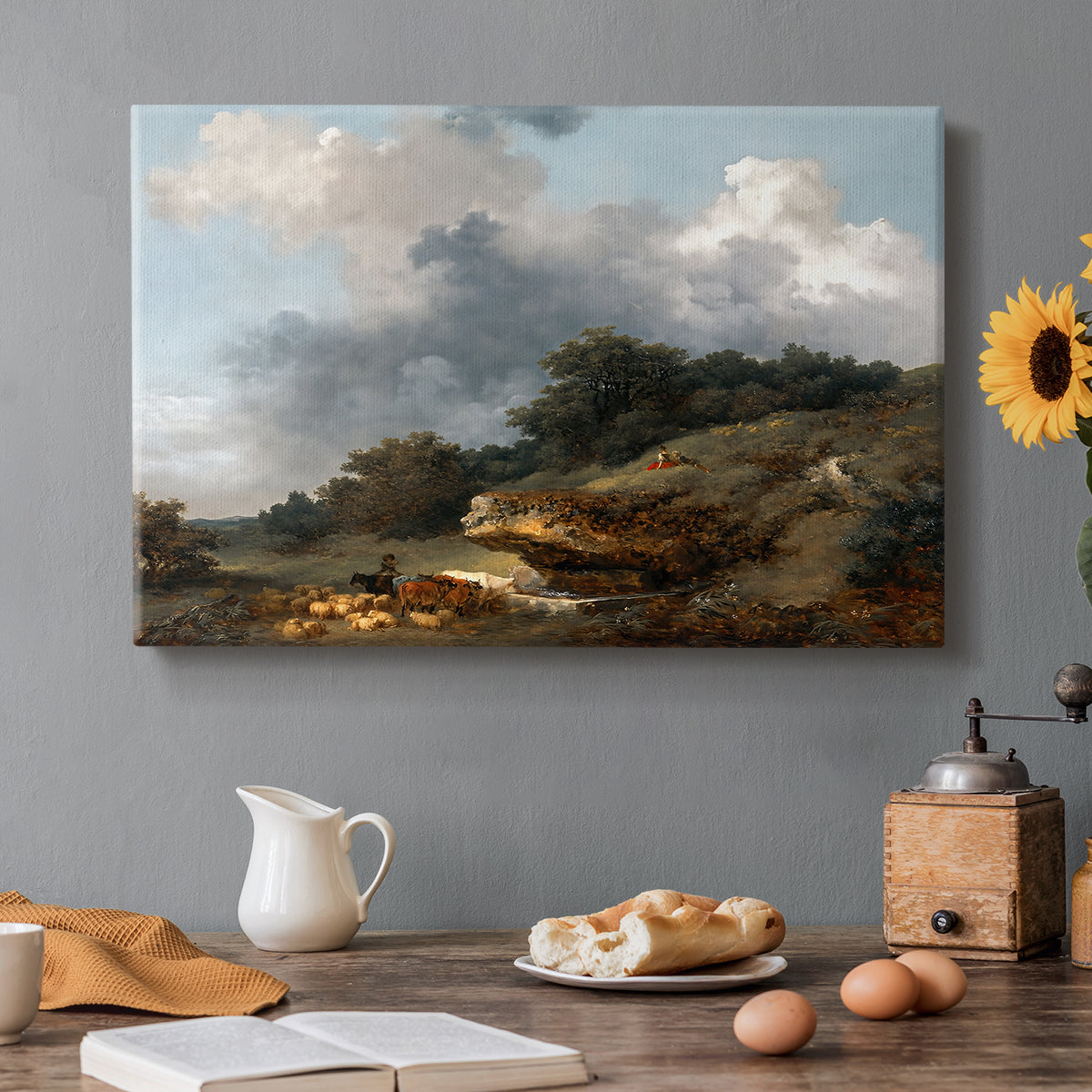 Canvas art print featuring a pastoral landscape with figures and animals gathered near water, set in a cozy kitchen setting