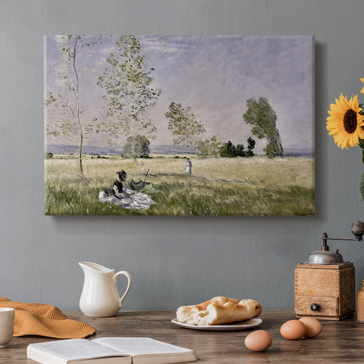Canvas art print featuring a woman seated in grassy field beneath tree in bright summer landscape, set in a cozy kitchen setting