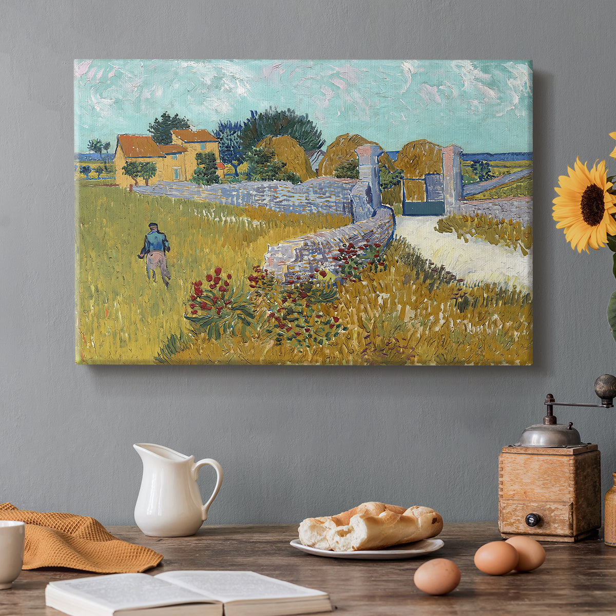 Canvas art print featuring a small farmhouse surrounded by yellow field and trees under blue sky, set in a cozy kitchen setting
