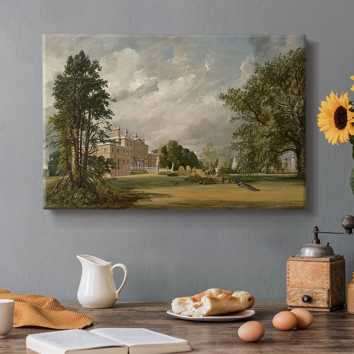 Canvas art print featuring a country house surrounded by trees in landscaped grounds, set in a cozy kitchen setting