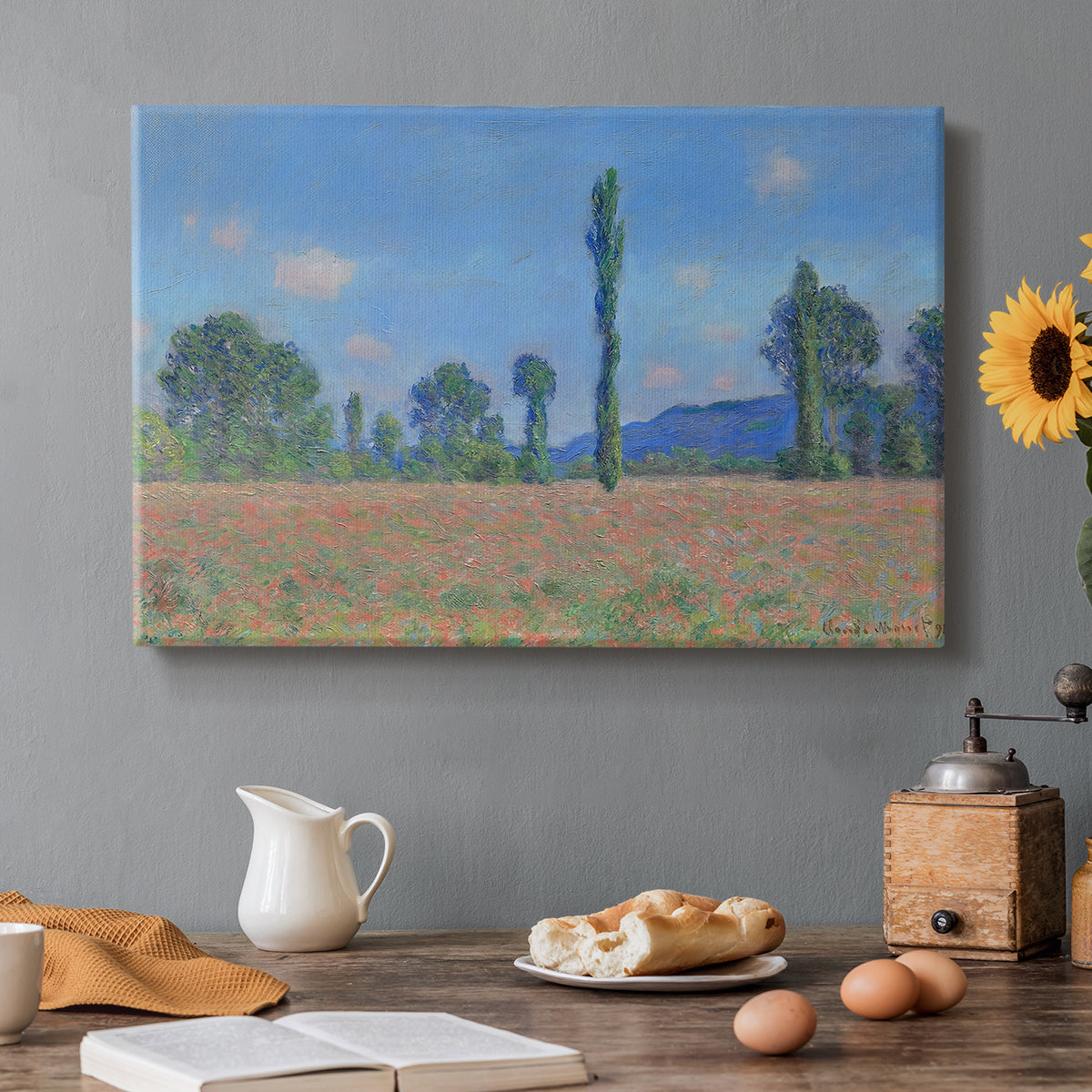 Canvas art print featuring an expansive field of red poppies with tall trees under blue sky, set in a cozy kitchen setting