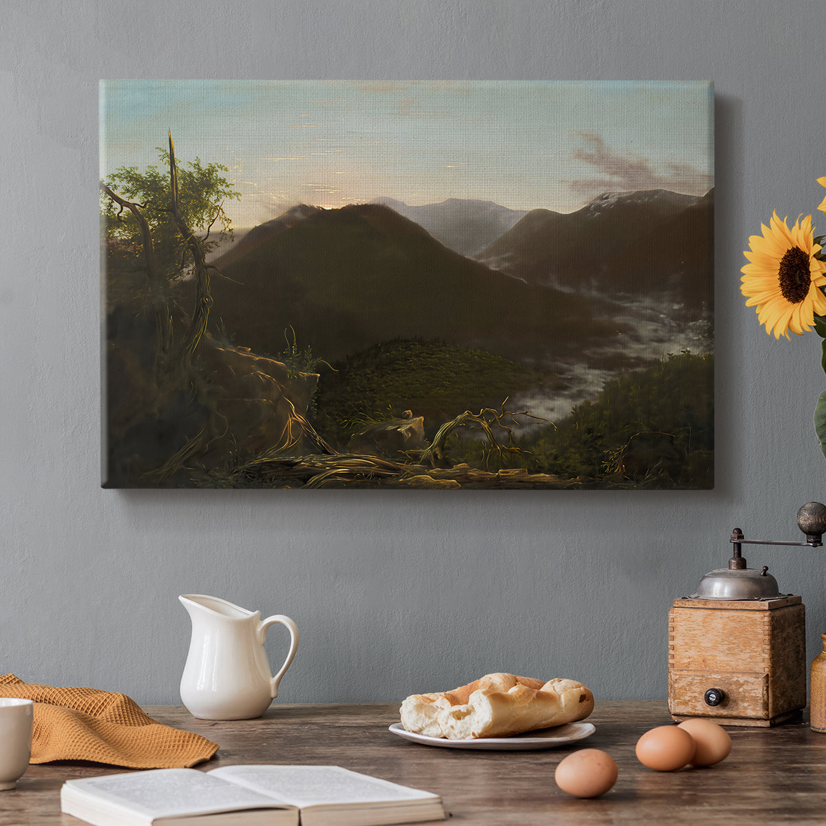 Canvas art print featuring a mountain valley at sunrise with light spreading across trees and hills, set in a cozy kitchen setting