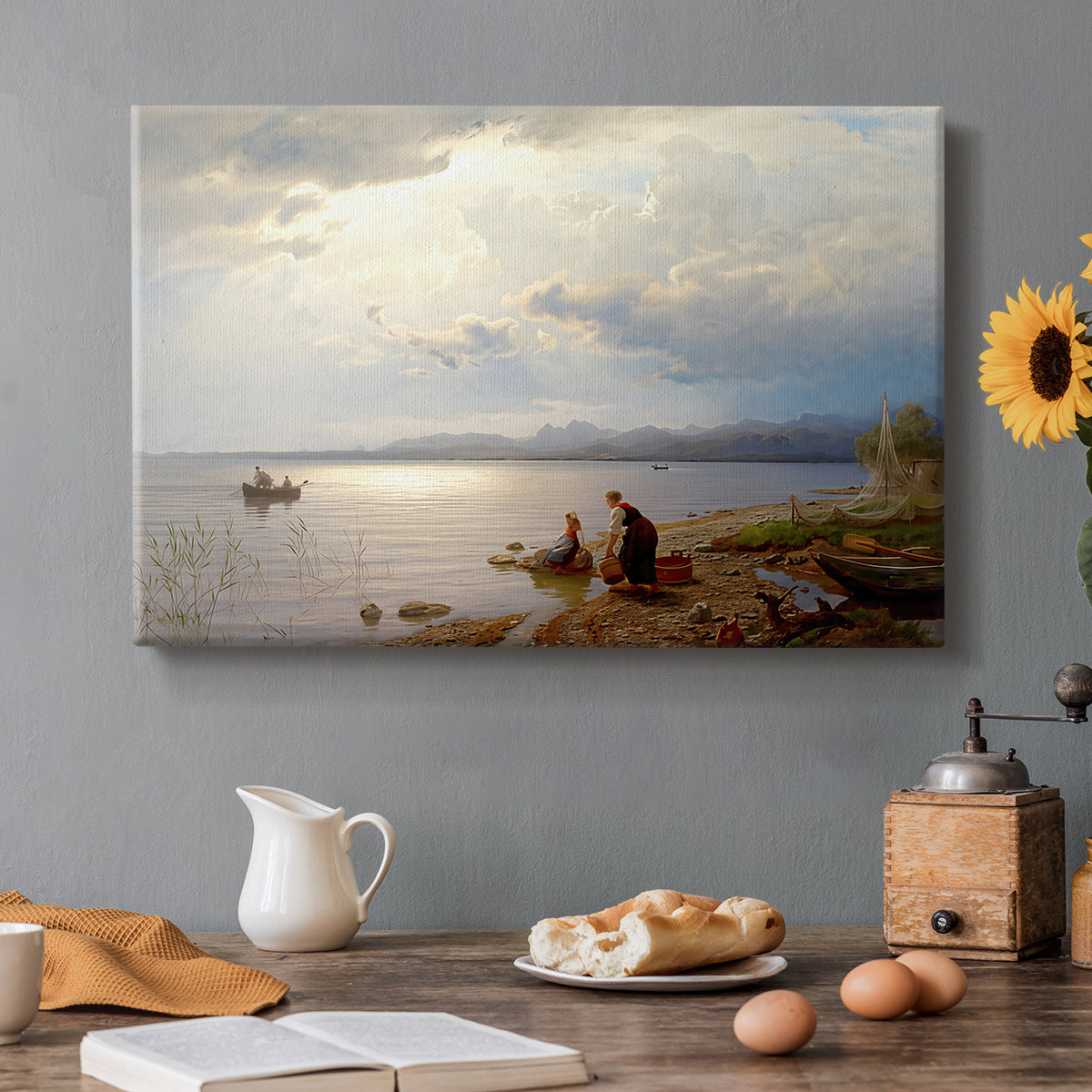 Canvas art print featuring figures gathered along shoreline with wide lake and distant horizon, set in a cozy kitchen setting