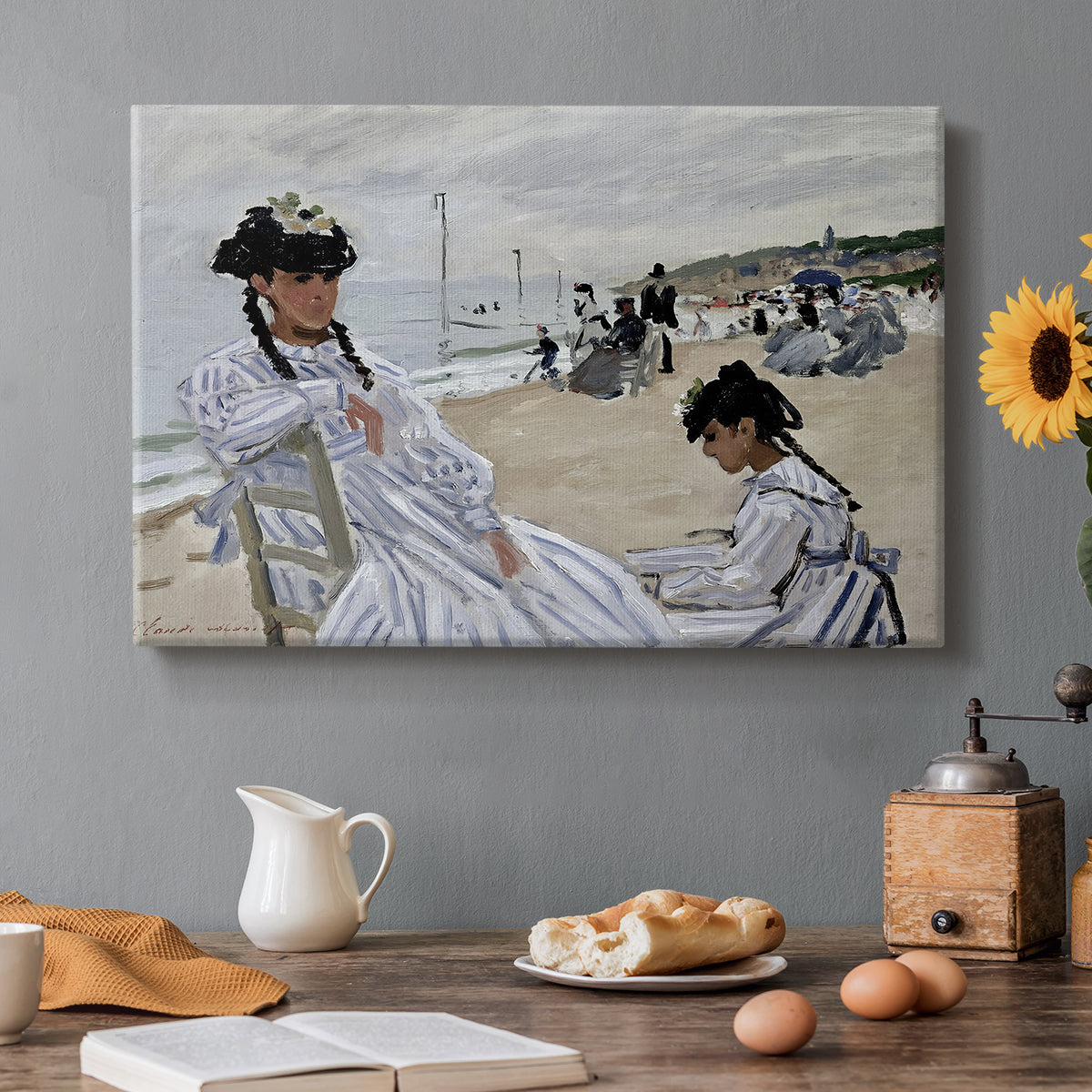Canvas art print featuring figures seated on beach with parasols facing the ocean, set in a cozy kitchen setting