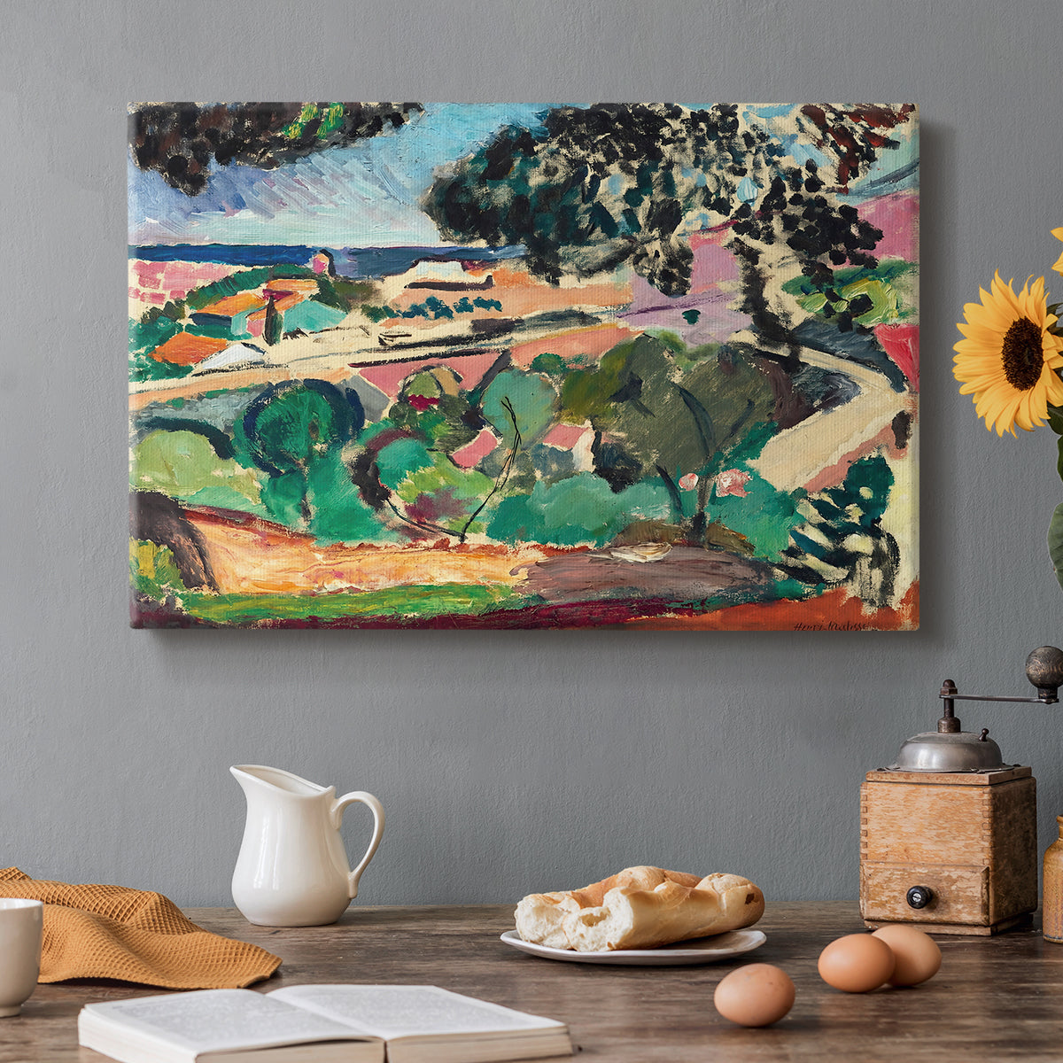 Canvas art print featuring a vivid landscape with hills, trees, and buildings near the coast, set in a cozy kitchen setting
