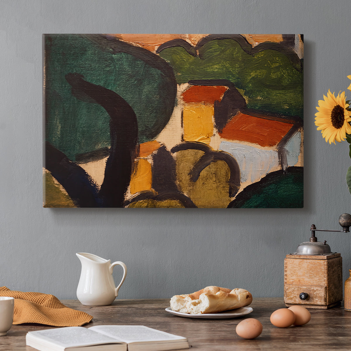Canvas art print featuring simplified houses and trees arranged in a geometric landscape, set in a cozy kitchen setting
