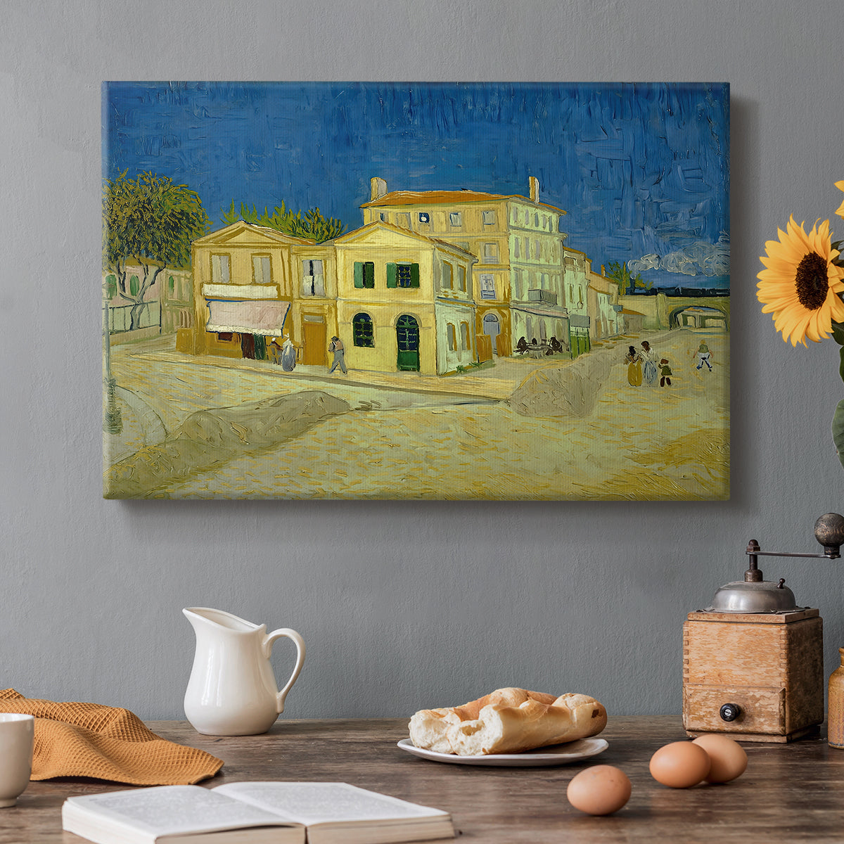 Canvas art print featuring a street view with bright yellow house and neighboring buildings under blue sky, set in a cozy kitchen setting