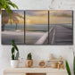 Three-panel canvas wall art featuring tropical beach at sunset photograph, displayed in a boho-chic entryway above a console table.