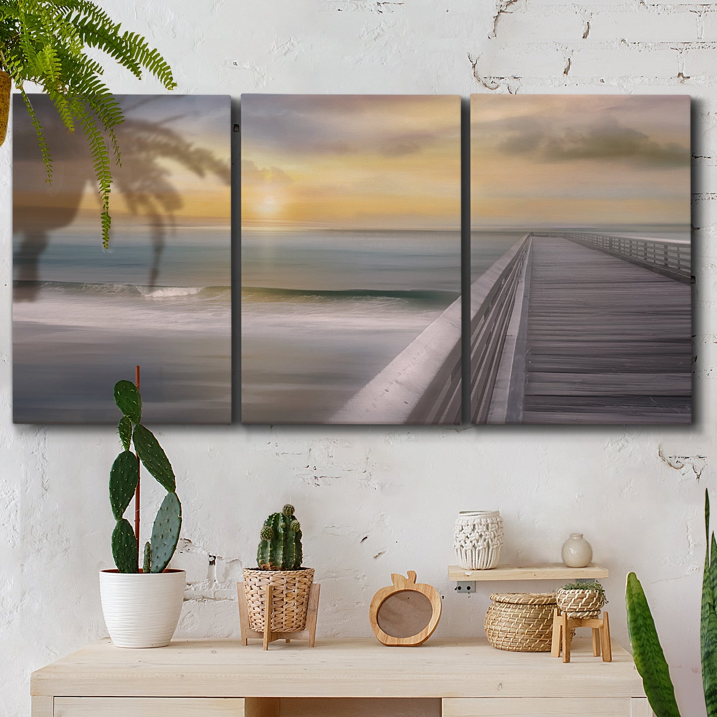 Three-panel canvas wall art featuring tropical beach at sunset photograph, displayed in a boho-chic entryway above a console table.
