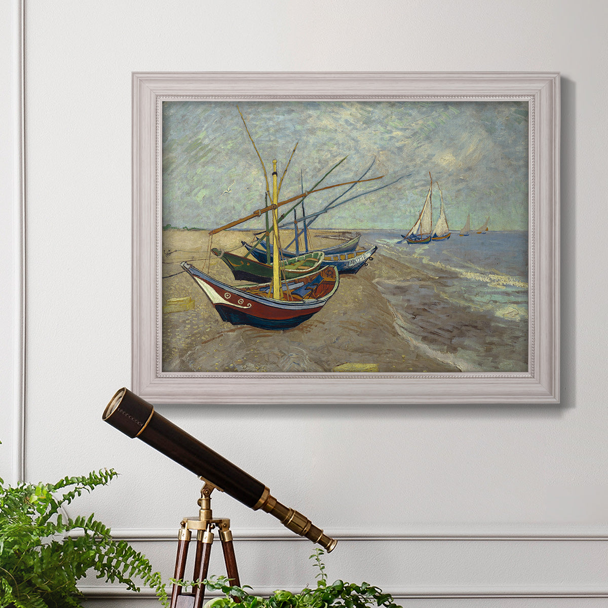 Impressionist coastal fishing boats scene by Vincent van Gogh in an ornate weathered white frame displayed in a light-toned interior setting.