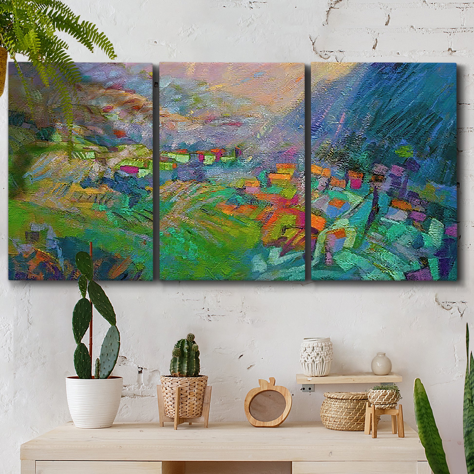 Three-panel canvas wall art featuring embracing landscape with warm tones, displayed in a boho-chic entryway above a console table.