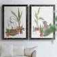 Set of two black barnwood framed canvas prints depicting curious felines, terracotta pots, succulents, and leafy stems arranged across two complementary compositions above a sofa in a bright living space.
