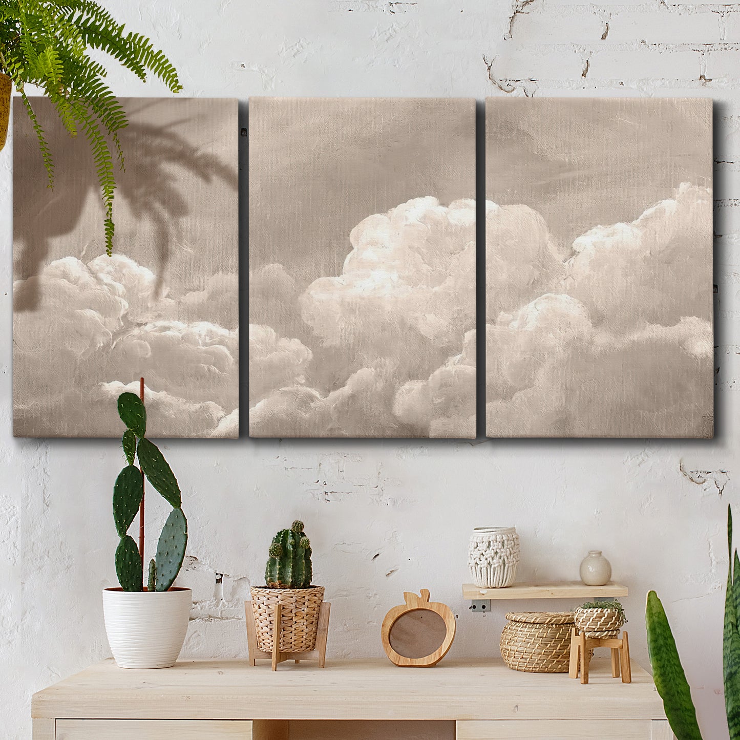Three-panel canvas wall art featuring soft whimsical cloudscape, displayed in a boho-chic entryway above a console table.