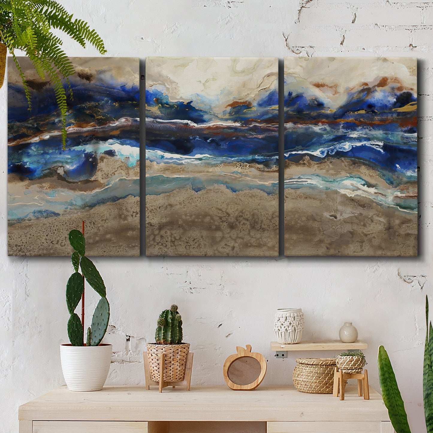Three-panel canvas wall art featuring abstract coastal jewel toned composition, displayed in a boho-chic entryway above a console table.