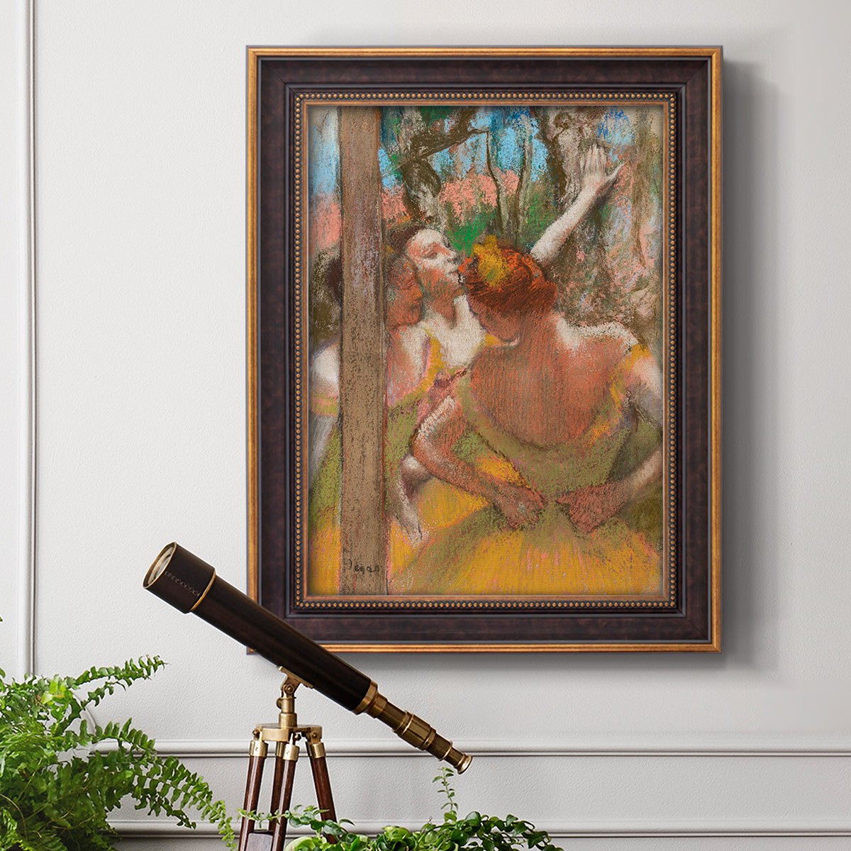 Impressionist ballet dancer composition by Edgar Degas in an ornate bronzed mahogany wood frame displayed in a light-toned interior setting.