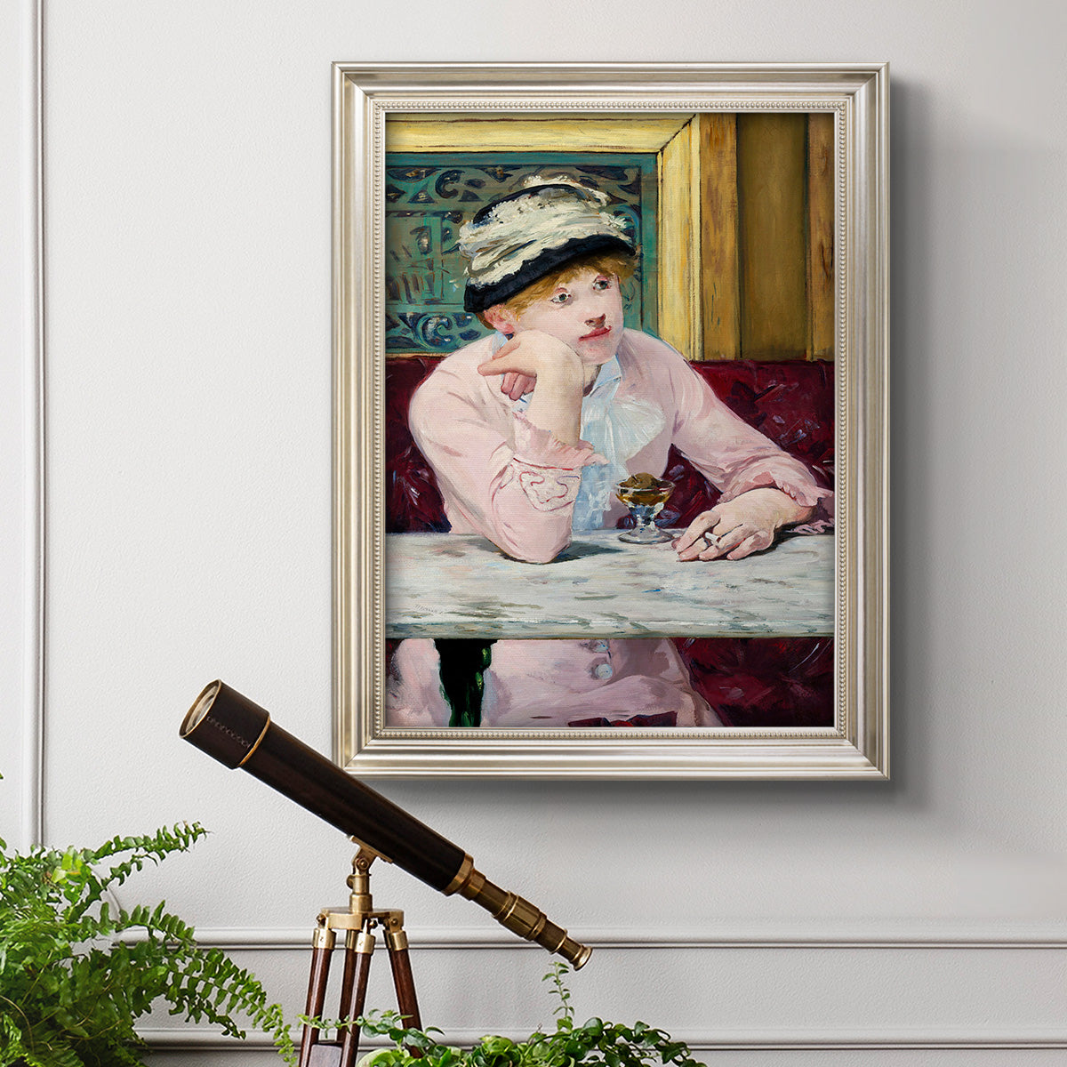 Impressionist portrait scene with plum brandy by Édouard Manet in an ornate champagne frame displayed in a light-toned interior setting.