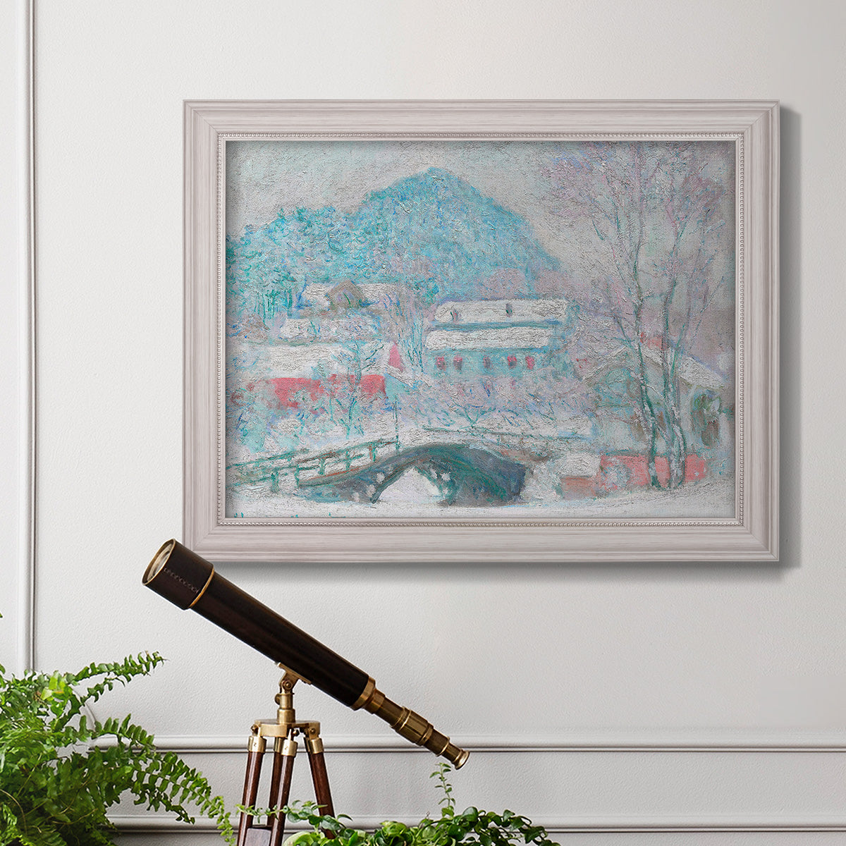 Impressionist coastal village landscape in Norway by Claude Monet in an ornate weathered white frame displayed in a light-toned interior setting.